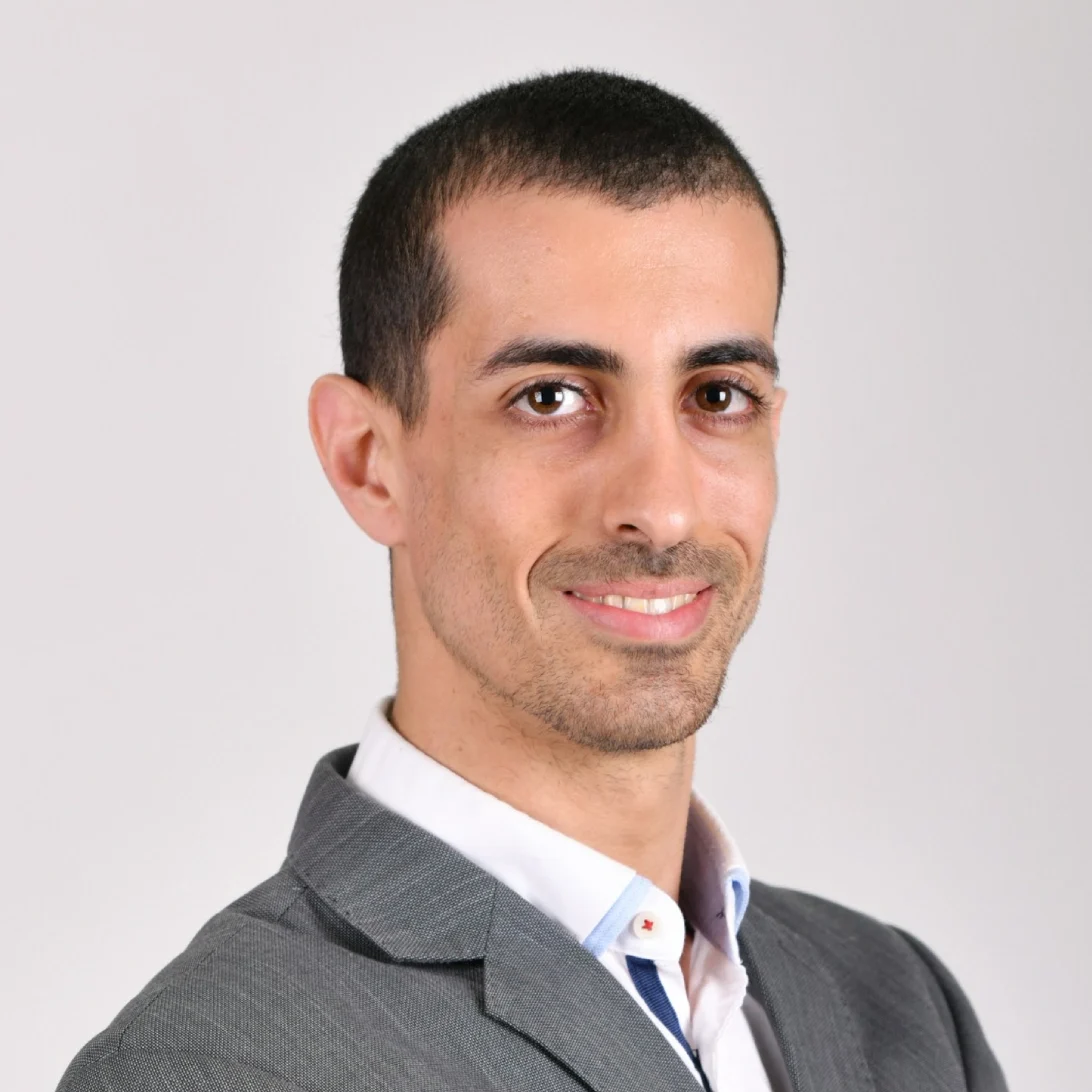 Smiling man in a gray suit.
